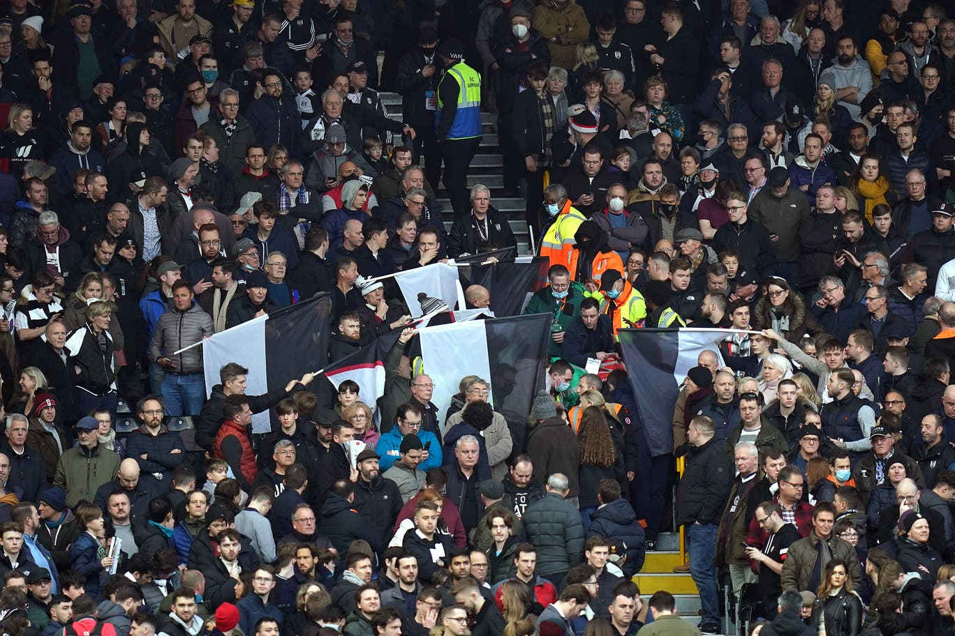 Tifosi coprono con le bandiere l'uomo che sta ricevendo i primi soccorsi